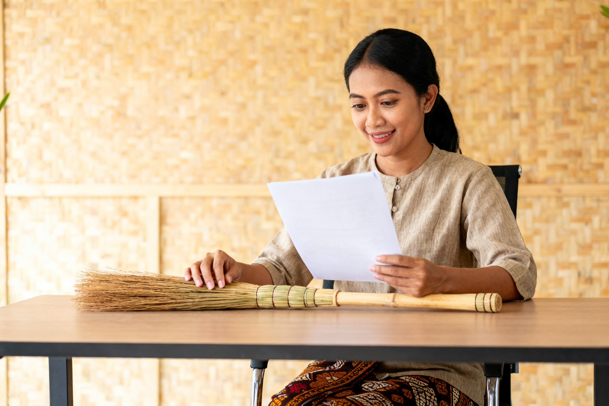 revitalisasi sapu tradisional lokal dengan pengrajin memeriksa sapu rotan ergonomis